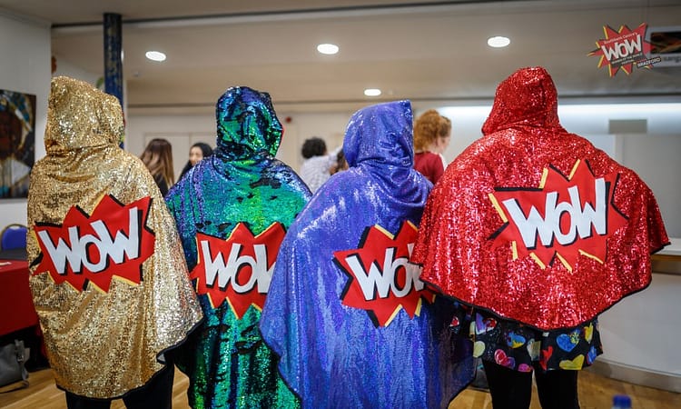 Four sparkly WoW capes being modelled here by four volunteers.