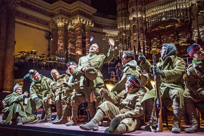 Adrian Clarke as Father Palmer with members of the Chorus of Opera North as the Scottish troops in Opera North’s production of Silent Night by Kevin Puts [Photo credit: Tristram Kenton]